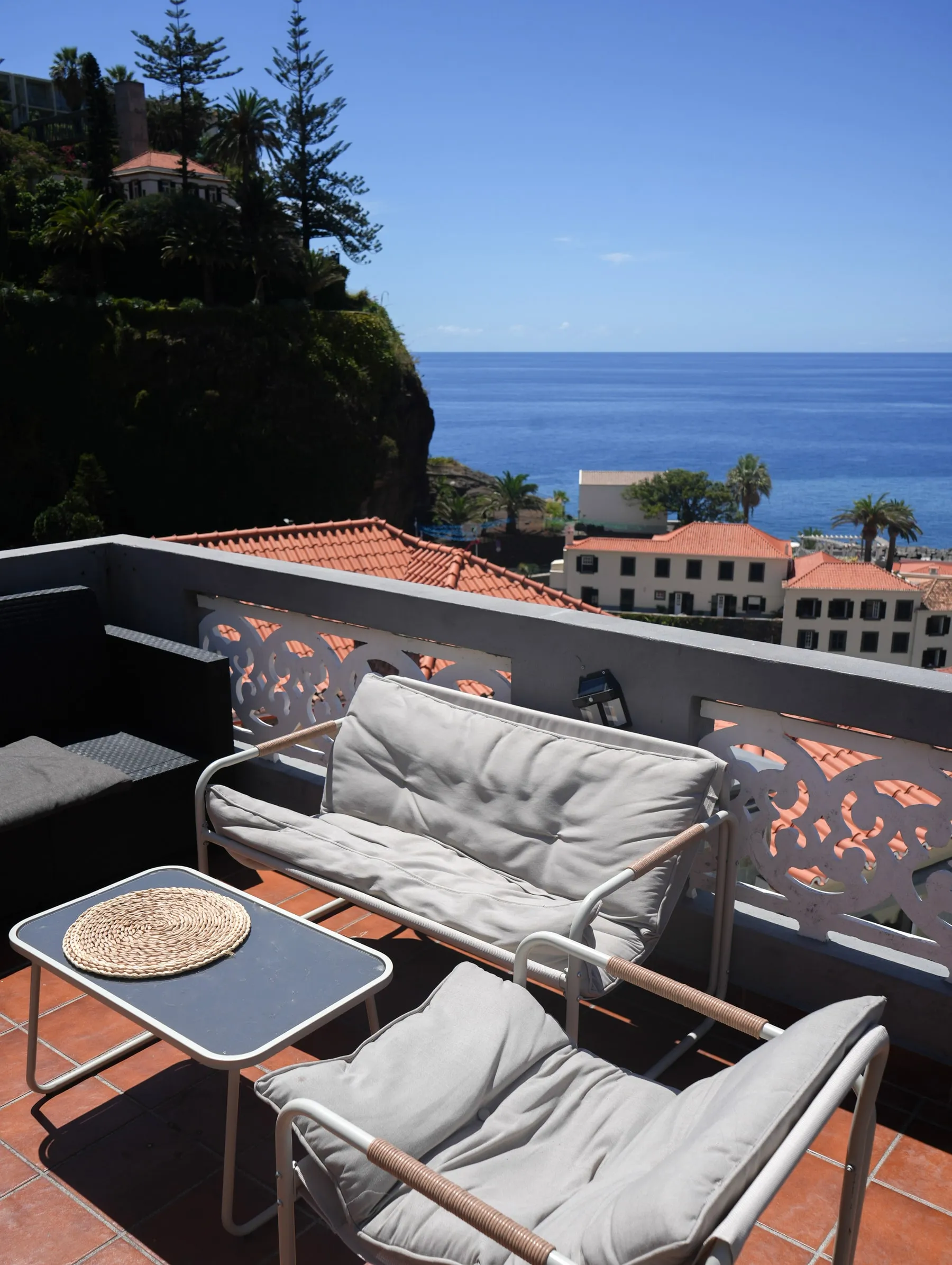 Shared balcony with cushioned seating overlooking Ponta do Sol and the Atlantic